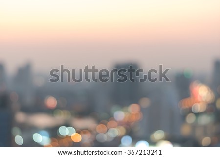 Blur abstract background aerial view Bangkok downtown city night light colorful twilight skyline bokeh in warm vintage gold color tone: Central business district on electric train line over river