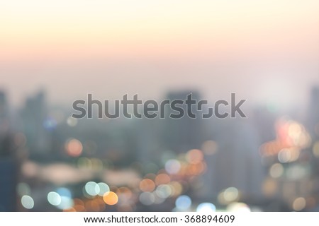 Blur abstract background aerial view Bangkok cbd downtown city night light colorful twilight skyline bokeh in warm vintage gold color tone: Central business district on electric train line over river