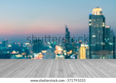Wood floor in light white grey gray color tone w/ blurred abstract background Bangkok cbd city night light rooftop view cool vintage style bokeh flare: Wooden table w/ blur backdrop of urban cityscape