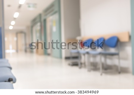 Blur abstract background of empty indoor hospital interior in hallway corridor lobby waiting area for patients, nurse, doctors and clinical staff circulation in clean, bright and hygienic environment