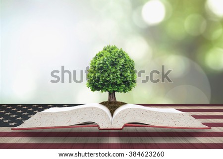 Tree of knowledge/ life growing from big archive open textbook on vintage USA flag pattern on old aged wood table, blur natural green background: Read across america day night concept: US CSR bio idea