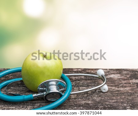 Green fresh organic natural nutrient apple with doctor\'s stethoscope heart shape on grunge old aged wood background blur bokeh:  World health day WHD symbolic conceptual design idea for healthy food