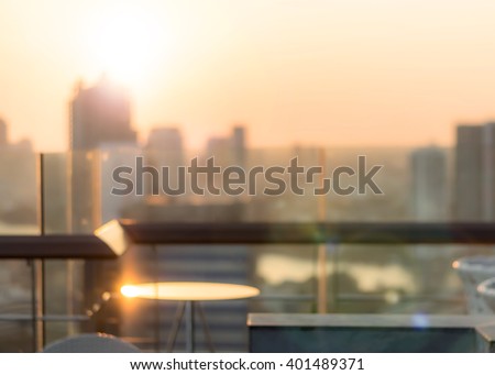 Blur abstract background restaurant dining table with Bangkok cbd city twilight gold evening light rooftop view warm vintage style bokeh flare: Glass table reflection w/ blur backdrop urban cityscape