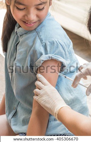 Young teenager girl looking at her arm & sharp syringe needle on skin while having medical vaccine injection by nurse for immunization: Healthcare immunisation polio prevention for child kid concept