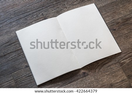 Blank open book, catalog, magazines, brochure, note template w/ paper texture on dark grey color wood table/ wooden floor background: Empty textured note book pages on timber backdrop for adding text