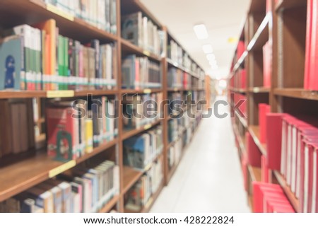 Blurred abstract background of book shelves row and interior of college library with textbooks, literature, menuscript, thesis, magazines, and seating for students and faculties for reading area
