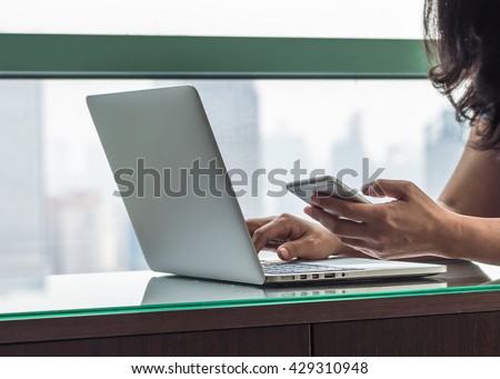 Modern casual city lifestyle woman hands working on computer typing laptop keyboard using IOT IT SEO wifi cyber internet online digital media technology pc device in urban office space environment