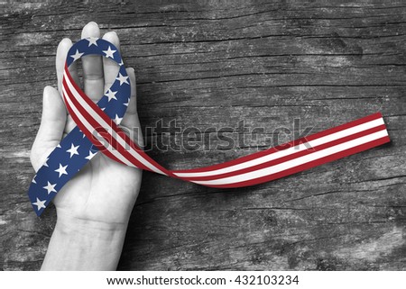 American flag pattern awareness ribbon color splashed on human hand grunge background: United states of america public holiday USA national day, nationalism raising US nation support campaign concept