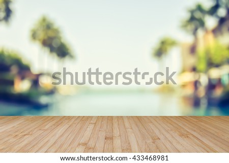 Wood floor natural wooden deck texture in light yellow beige brown color tone w/ blur abstract background blurry view tropical resort hotel swimming pool seaside ocean view coconut palm tree blue sky
