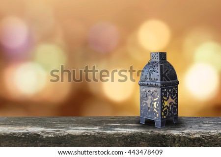 Ramadan kareem lantern on grunge antique wood table floor w/ blur festive colorful gold candle light illumination pattern background: Islamic calendar muslim religious fasting month worldwide concept