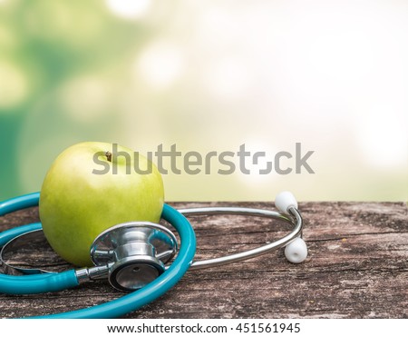 Green fresh organic natural nutrient apple with doctor\'s stethoscope heart shape on grunge old aged wood background blur bokeh: World health day WHD symbolic conceptual design idea for healthy food