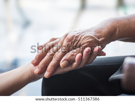 National family care giver month, World Kindness Day concept: Wrinkle hand of Parkinson disease patient/ elderly aging senior citizen person in support of nursing caregiver: Adult day care center week