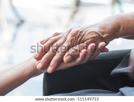 National family care giver month, World Kindness Day concept: Wrinkle hand of Parkinson disease patient/ elderly aging senior citizen person in support of nursing caregiver: Adult day care center week