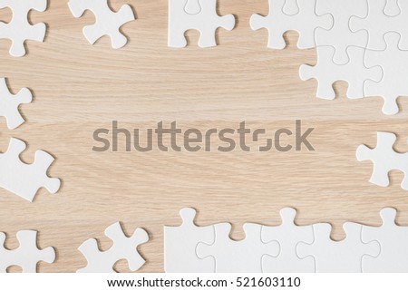 Jigsaw puzzle game paper piece texture pattern on light cream brown wood table desk wooden background: National Game & Puzzle Week: Idea brain training educational/ business problem solution concept