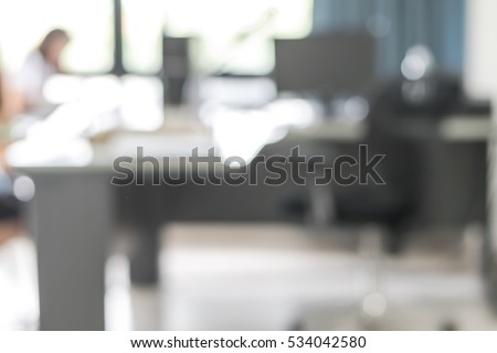 Blur abstract background interior business office working space with pc personal computer monitor screen in white room near bright light glass window curtain wall: Blurry comfy view workplace