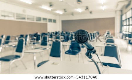 Microphone soft focus on blur abstract background lecture hall/ seminar meeting room in business event/ educational academic classroom training course: Speaker / teacher\'s mic in college class room