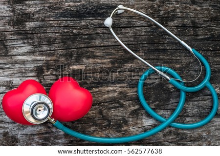 Two red heart love shape hand exercise ball couple with MD medical doctor physician\'s stethoscope on old age wood background: Hospital life insurance healthcare concept: World heart health day idea