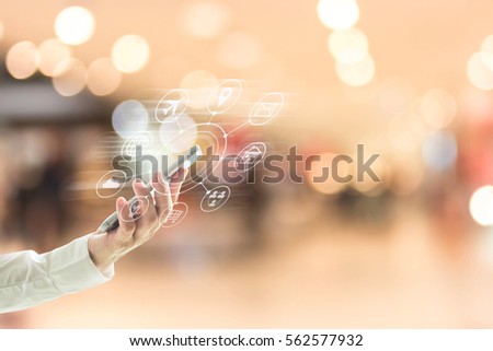 Business person hand using cellphone omni-channel shopping with tech icon flow on blur abstract background shopping mall department store: Woman user typing mobile phone buying purchase payment
