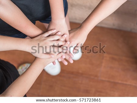 Young student girl kids group stacking joining hands heap together top view from above: Unity harmony teamwork circle of friends concept: Union friendship connection collaborative collaboration idea