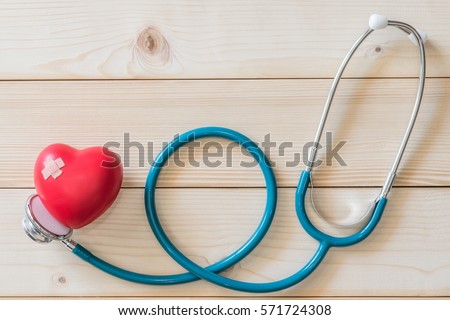 One single red heart love shape with cross bandage and medical doctor physician\'s stethoscope on white wood background: Hospital healthcare insurance business conceptual idea: World health day concept