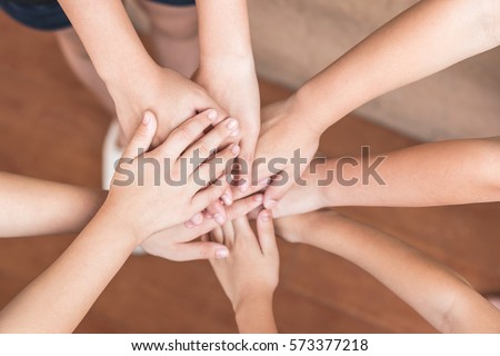 Young school student girl kids group stacking joining hands together top view from above: Unity harmony teamwork circle of friends concept: Union friendship connection collaborative collaboration