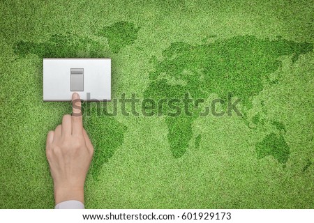 Business woman human hand turn off switch light button on natural green lawn grass wall background: Earth hour promotion campaign concept: Saving energy efficiency ecological friendly conceptual idea