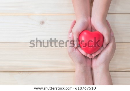 I love you Mom, Mother\'s woman hand holding daughter, son child kid palm supporting red heart ball, light white wood background: Nursing children home day healthcare concept: Hospital medical business