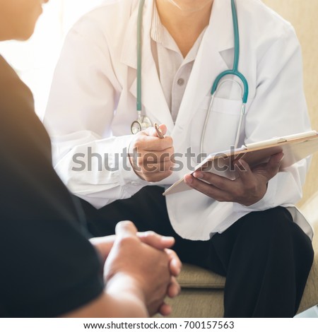 Doctor consulting male patient, working on diagnostic examination on men\'s health disease or mental illness, and writing on prescription record information document in clinic or hospital office