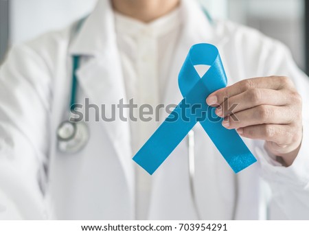 Blue ribbon symbolic for prostate cancer awareness campaign and men\'s health in doctor\'s hand