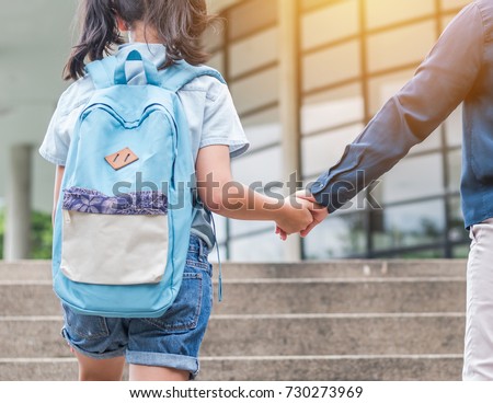 Back to school first day education concept with girl kid (elementary student) carrying backpacks holding parent woman or mother\'s hand walking up school building stair going to class