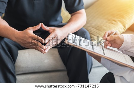 Male patient having consultation with doctor or psychiatrist who working on diagnostic examination on men\'s health disease or mental illness in medical clinic or hospital mental health service center