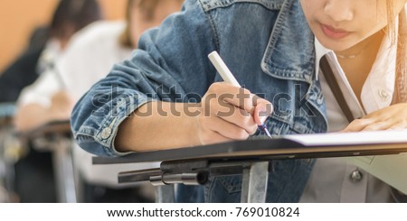 School student\'s taking exam, thinking hard, writing answer in classroom for educational university admission test  and world literacy day concept