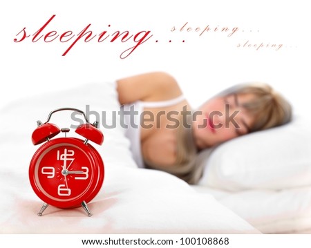 Beautiful young woman is sleeping in the bed, with alarm clock in the front