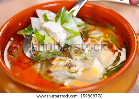Thin chicken broth with chunks of chicken and vegetables