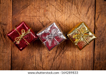 Red, silver and golden Christmas gift boxes on aged wooden table. Above view.
