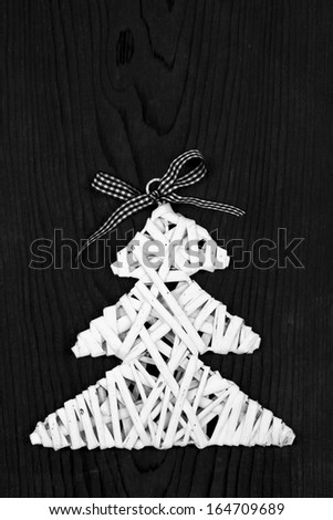 White wooden rod Christmas tree shape decoration on black wooden table background.