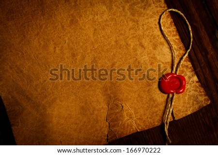Empty parchment with wax seal stamp on bottom side, wooden background