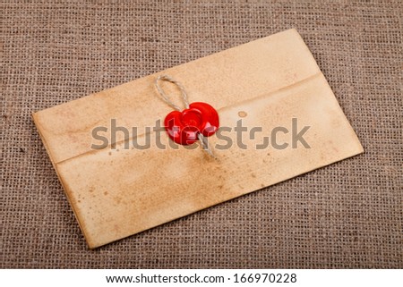 Old vintage letter with wax seal on burlap background.