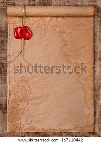 Empty parchment with red wax seal stamp on burlap background