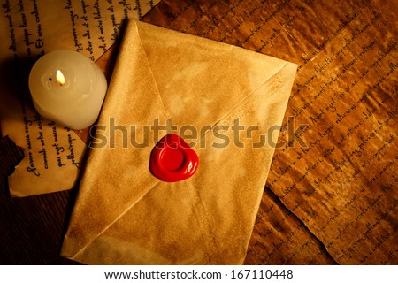Vintage closed envelope with red wax seal stamp and candle