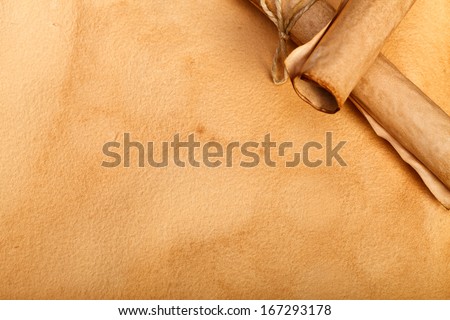 Old paper rolls in right corner on aged paper background.