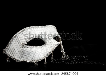 Silver glittering carnival mask and black pearls