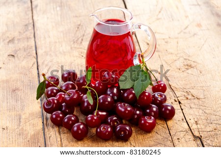 Cherry drink with ripe cherry berries on the table, rustic style