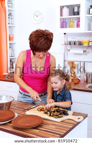 Mother and daughter making a cake with damson plums