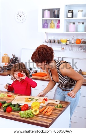 Mother with daughter laughing in the kitchen