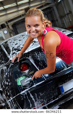 Sexy blonde cleans the rear lights of a sport car
