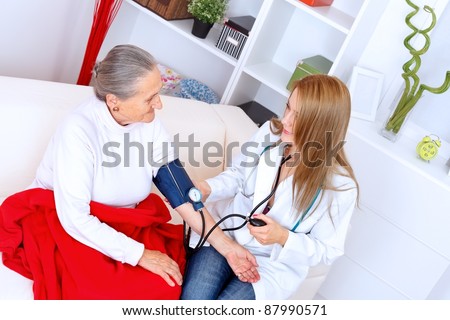 Elderly woman has her blood pressure checked by the nurse