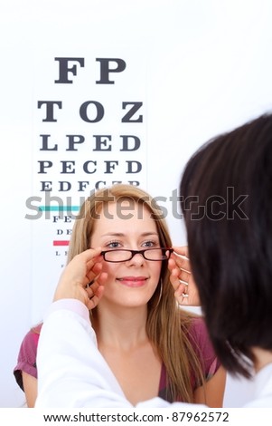Optician helps woman to choose the best pair of glasses