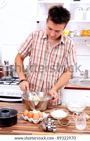 Handsome man preparing cake in the kitchen