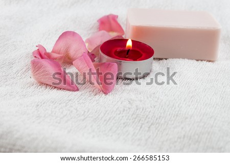 light pink rose,soap with tea light candle on white towel